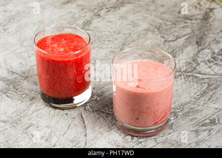 Verres de smoothie fraîche avec des fruits et des baies, sur fond de béton Banque D'Images