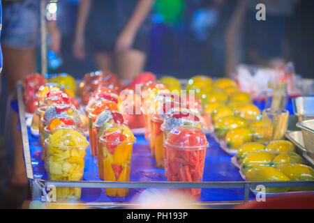 Salade de fruits disposés dans des gobelets en plastique pour la vente sur rue à Bangkok, Thaïlande, du marché de nuit. Banque D'Images