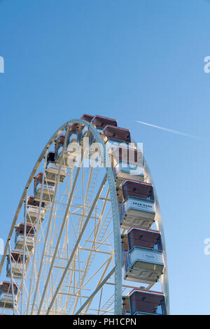 26 août 2018 - Genève, Suisse. Vertical image de la Grande Roue cabines contre le ciel bleu et l'avion en vol. Banque D'Images