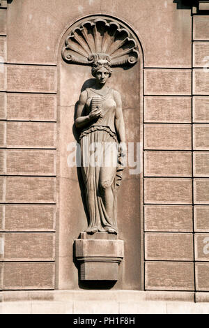 Mesdames Sculptures sur le mur. Sculptures chers une partie de la façade. Une belle statue de femme tenant une ruche dans son bras droit. Banque D'Images