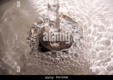 Les éclaboussures d'eau dans le lavabo. Lieux aux projections d'eau verser de l'eau forte avec beaucoup de bulles d'eau dans l'évier, Close up Banque D'Images