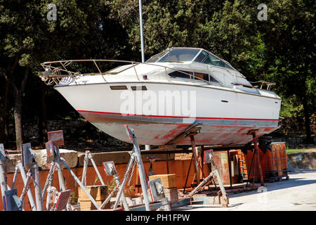 Location de bateau à moteur dans le port. Bateau yacht blanc sur la structure de l'entretien du port. Yacht en bois hors de la mer pour l'entretien du port. Banque D'Images