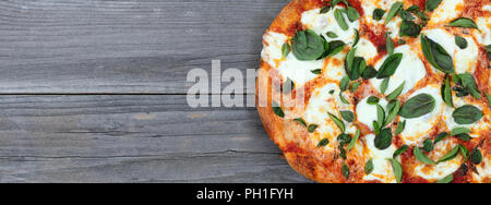 Vue de dessus de tomate et de fromage pizza cuite sur maison en bois rustique Banque D'Images