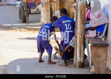 SAINT LOUIS, SÉNÉGAL - Apr 24, 2017 : les petits garçons sénégalais non identifiés dans uniforn ramasser quelque chose du sol sur le marché local de Saint Lou Banque D'Images