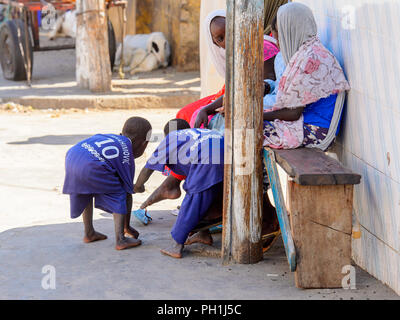 SAINT LOUIS, SÉNÉGAL - Apr 24, 2017 : les petits garçons sénégalais non identifiés dans uniforn ramasser quelque chose du sol sur le marché local de Saint Lou Banque D'Images