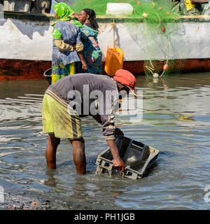 SAINT LOUIS, SÉNÉGAL - Apr 24, 2017 : l'homme sénégalais non identifiés se lave la boîte dans l'eau dans le port de Saint Louis, une des plus grandes villes dans Banque D'Images