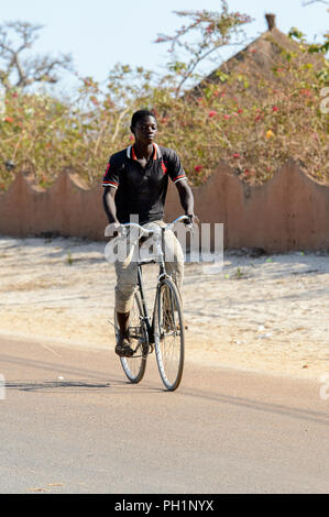 LAC ROSE, AU SÉNÉGAL - Apr 26, 2017 : Unidentified sénégalais monte un vélo sur la côte du lac salé Lac Retba, Site du patrimoine mondial de l'UNESCO Banque D'Images