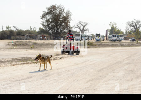 LAC ROSE, AU SÉNÉGAL - Apr 26, 2017 : Un homme monte un quad sur la côte du lac salé Lac Retba, Site du patrimoine mondial de l'UNESCO Banque D'Images