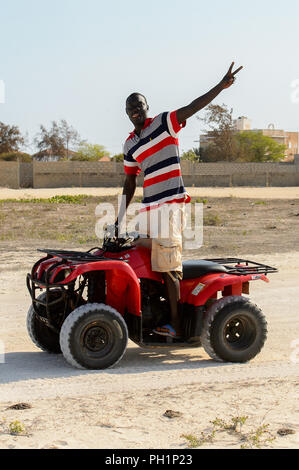 LAC ROSE, AU SÉNÉGAL - Apr 26, 2017 : Un homme monte un quad sur la côte du lac salé Lac Retba, Site du patrimoine mondial de l'UNESCO Banque D'Images
