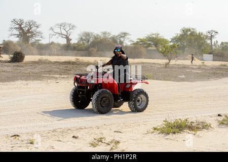 LAC ROSE, AU SÉNÉGAL - Apr 26, 2017 : Un homme monte un quad sur la côte du lac salé Lac Retba, Site du patrimoine mondial de l'UNESCO Banque D'Images