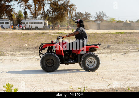 LAC ROSE, AU SÉNÉGAL - Apr 26, 2017 : Un homme monte un quad sur la côte du lac salé Lac Retba, Site du patrimoine mondial de l'UNESCO Banque D'Images