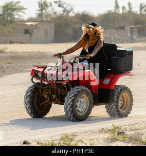 LAC ROSE, AU SÉNÉGAL - Apr 26, 2017 : une femme non identifiée monte un quad sur la côte du lac salé Lac Retba, Site du patrimoine mondial de l'UNESCO Banque D'Images