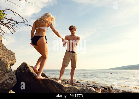 Dans l'amour couple holding hands at the beach at summer Banque D'Images