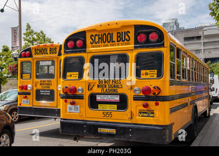 TORONTO, CANADA - 14 août 2018 : deux autobus scolaires dans le trafic en centre-ville de Toronto, Canada. Banque D'Images