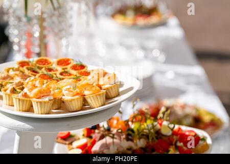 Banquet solennel. Beaucoup de verres de champagne ou de vin sur la table dans un restaurant. table de buffet avec plein de délicieux en-cas. canapes, bruschetta, et peu de desserts sur plaque de bois board Banque D'Images