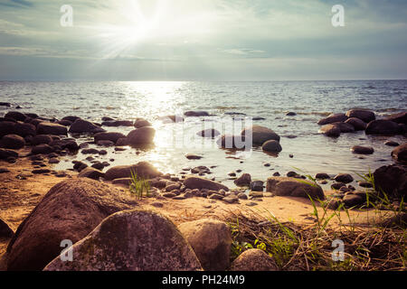 Plage rocheuse dans le coucher du soleil Banque D'Images