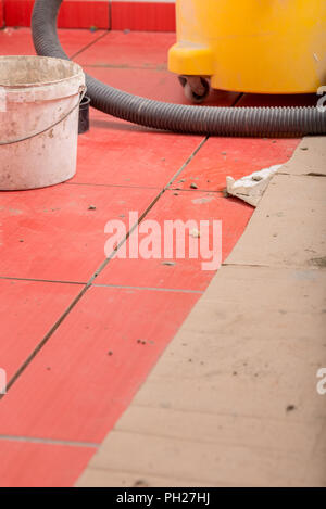 Libre de fraîchement posés les carreaux avec un seau et un aspirateur en arrière-plan. Construction et rénovation concept. Banque D'Images