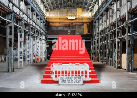 L'Allemagne, Leipzig. Août 24, 2018. Une barrière "ne pas marcher sur l'art" se place en avant d'une installation semi-finis par Victor Freso, un immense escalier rouge dans une usine. Le Festival d'Art Urbain 'Monumenta' ouvre le 1er septembre dans l'usine vide de l'ex-Pittlerwerke salles. La Monumenta présente le graffiti, le street art et l'art contemporain autour de 6 000 mètres carrés jusqu'au 13 octobre. Crédit : Jan Woitas/dpa-Zentralbild/dpa/Alamy Live News Banque D'Images