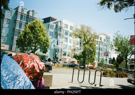 Bâches et tentes d'un campement de sans-abri dans la région de Berkeley, Californie avec nouvel immeuble en arrière-plan, sur l'Avenue Shattuck, le 17 mai 2018. () Banque D'Images