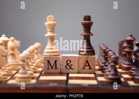 Close-up of king Pièces des échecs sur des blocs de bois avec les fusions et acquisitions Banque D'Images
