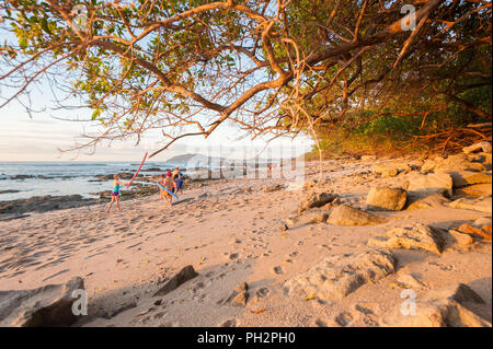 Les gens qui marchent sur la plage rocheuse entre Tamarindo et plages Langosta Banque D'Images