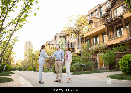 Happy young couple shaking hands with realtor Banque D'Images