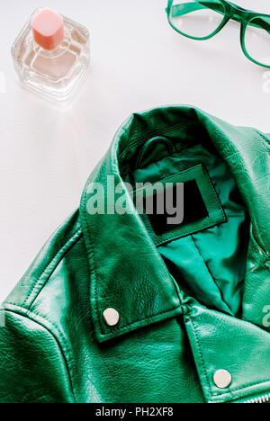 Veste en cuir vert et lunettes vertes sur fond blanc Banque D'Images