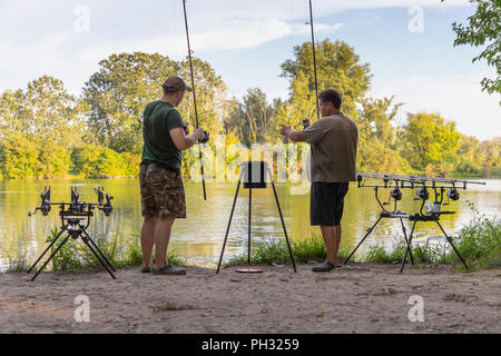 Pêcheur sur une action de pêche de la carpe dans le lac Banque D'Images