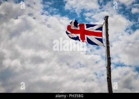 Une Union Jack britannique, probablement xvie siècle réplique, battant avec les nuages en arrière-plan. Banque D'Images