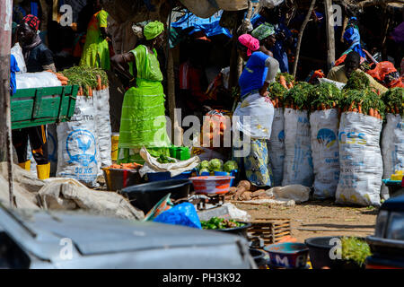 KAYAR, SÉNÉGAL - AVR 27, 2017 : femme sénégalaise non identifié en vert vêtements et foulard vend des légumes au marché local de Kayar, au Sénégal. Banque D'Images