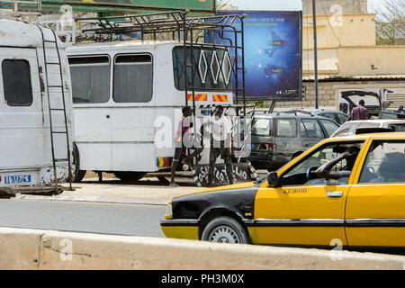 DAKAR, SÉNÉGAL - Apr 27, 2017 : deux garçons sénégalais non identifiés le bus stand behid blanc à Dakar, capitale du Sénégal Banque D'Images