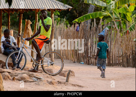 OUSSOUYE, SÉNÉGAL - Apr 30, 2017 : l'homme sénégalais non identifiés s'assied sur son vélo dans la forêt sacrée près de Kaguit village Banque D'Images