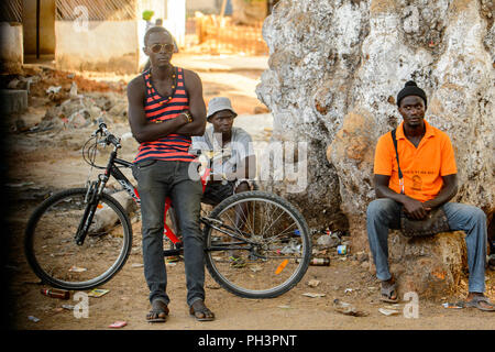 Route de BISSAU, GUINÉE B. - 1 mai 2017 : l'homme local non identifié s'appuie sur la bicyclette dans un village en Guinée Bissau. Encore beaucoup de gens dans le pays l Banque D'Images