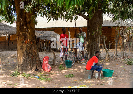 Route de BISSAU, GUINÉE B. - 1 mai 2017 : local non identifié, l'homme est assis sur le vélo dans un village en Guinée Bissau. Encore beaucoup de gens dans le pays li Banque D'Images