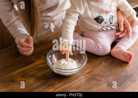Famille heureuse loveling préparer la pâte ensemble. Mère et fille s'amuser dans la cuisine. Cuisine maison et little helper. Banque D'Images