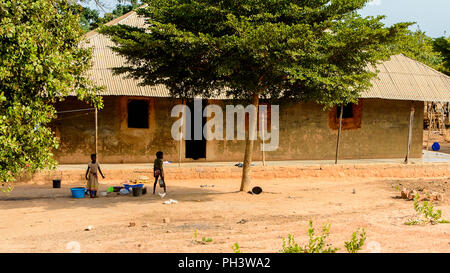 Route de BISSAU, GUINÉE B. - 1 mai 2017 : petite fille local non identifié est titulaire d'un bassin dans un village en Guinée Bissau. Encore beaucoup de gens dans le pays Banque D'Images