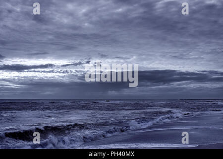 Plage vide avec ciel nuageux. Tons infrarouge bleu. Vila do Conde, Nord du Portugal Banque D'Images