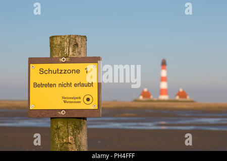 Panneau indiquant la Zone de Protection 1 en face de Westerheversand phare dans les marais salés. Presqu'île d'Eiderstedt, Frise du Nord, Allemagne Banque D'Images