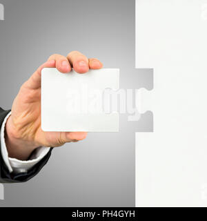 Businessman holding la pièce manquante pour compléter le casse-tête dans sa main de la solution conceptuelle d'un problème ou d'effectuer une tâche. Banque D'Images