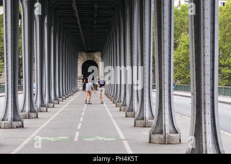 Deux hommes sur skateboards équitation le long du pont Bir Hakeim à Paris, France. Banque D'Images