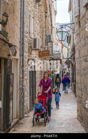 Budva, Monténégro - Avril 2018 : Mère et père, avec leurs enfants et buggy découvrez paris les rues étroites de la vieille ville de Budva Banque D'Images