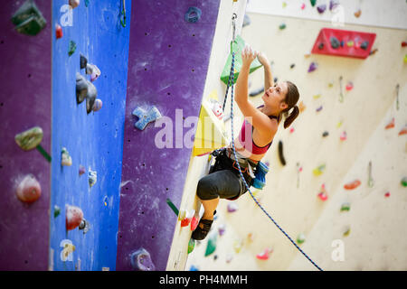 Photo de femme sac de sport avec du talc derrière son dos la pratique sur un mur d'escalade Banque D'Images