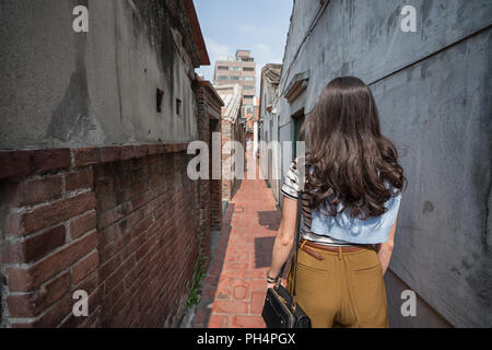 Asian woman standing dans la ruelle étroite. vue depuis l'arrière. Banque D'Images