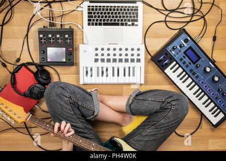 Jeune femme jouant de la guitare électrique, le coup de point de vue. Vue de dessus de productrice à l'enregistrement en studio de la guitare et les instruments électroniques. Banque D'Images