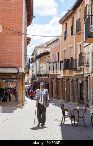 Vieil homme avec bâton de marche marche à travers la ville médiévale fortifiée de Uruena connu sous le nom de la ville de books Valladolid Castille et Leon Espagne Banque D'Images