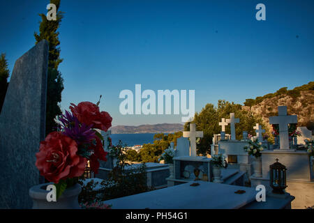 Tous les dean dans un cimetière et des fleurs tout autour, mais ce que je vois, c'est une ville un village une vie qui est toujours en cours et sur dans un ciel bleu et ensoleillé et rouge Banque D'Images