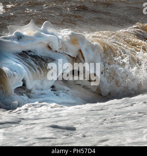 Vagues se brisant sur les disjoncteurs de mousse et shore Banque D'Images