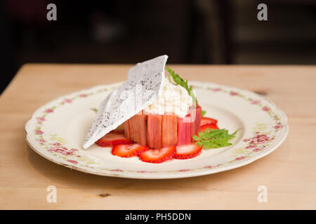 La rhubarbe fraise moderne dessert gâteau au fromage avec une gaufrette de meringue. Banque D'Images