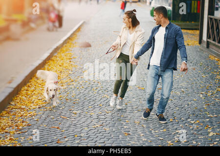 Couple en train de marcher leur chien sur une journée ensoleillée d'automne Banque D'Images