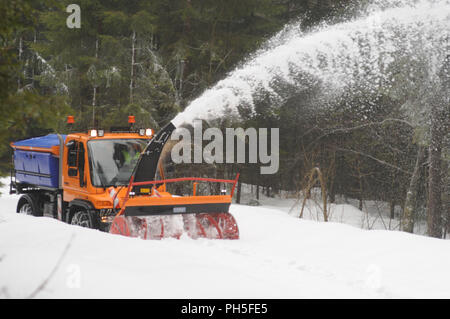 Fraiseuse à neige au travail le nettoyage d'un chemin forestier Banque D'Images